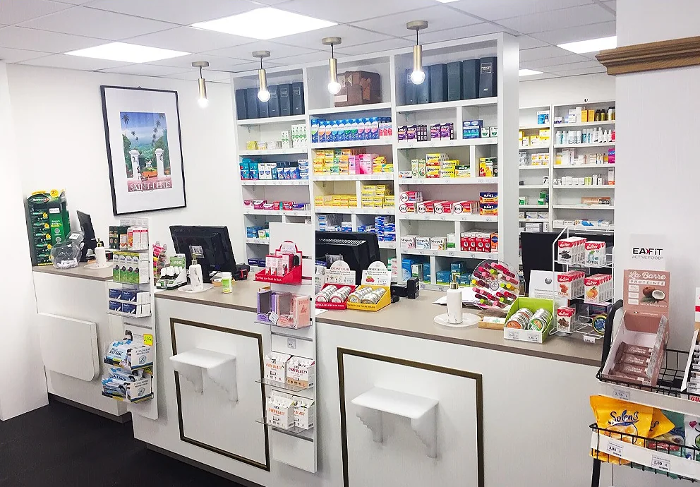 Le comptoir de délivrance d'une pharmacie, mobilier blanc et rayonnages